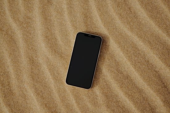 Smartphone mockup on sandy texture, ideal for showcasing UI/UX designs, minimalist mobile device display for digital assets.